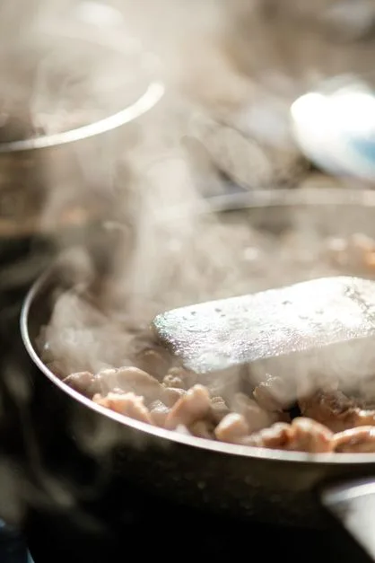 Steam rising in commercial kitchen showing why exhaust fan cleaning matters