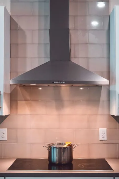 Stainless steel commercial kitchen hood above cooking line in Cherry Hill restaurant